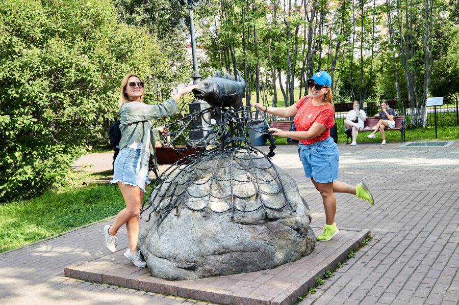 Туристы у скульптуры рыбы в Мурманске
