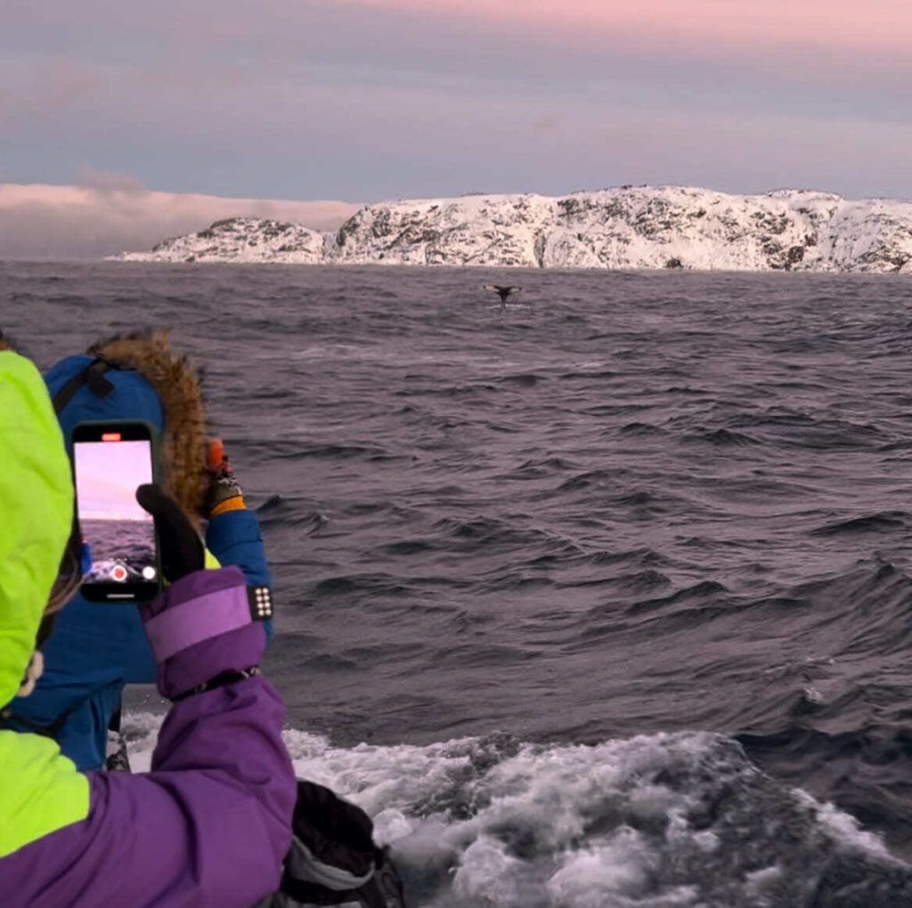 Guest on a boat beside the snow-covered Teriberka coast